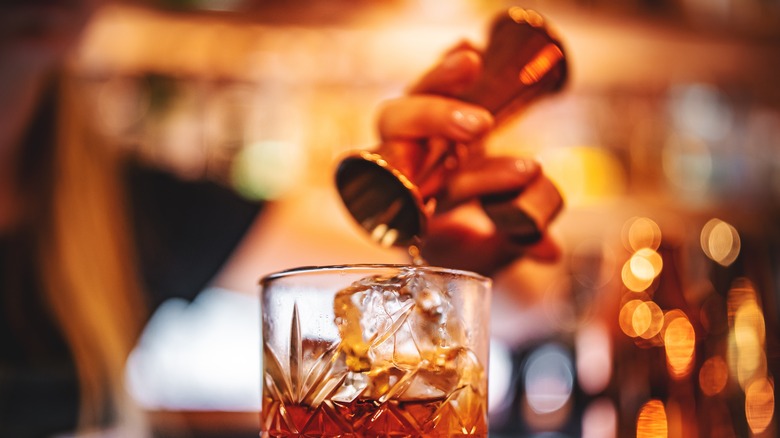 Hand pouring liquor into glass