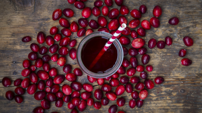 Glass of cranberry juice surround by cranberries