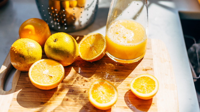 Pitcher of orange juice and oranges