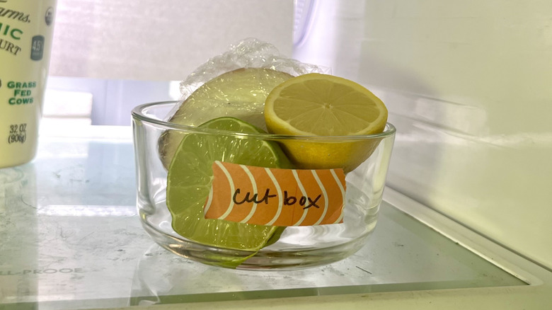 Glass bowl with halved lime, lemon, and onion