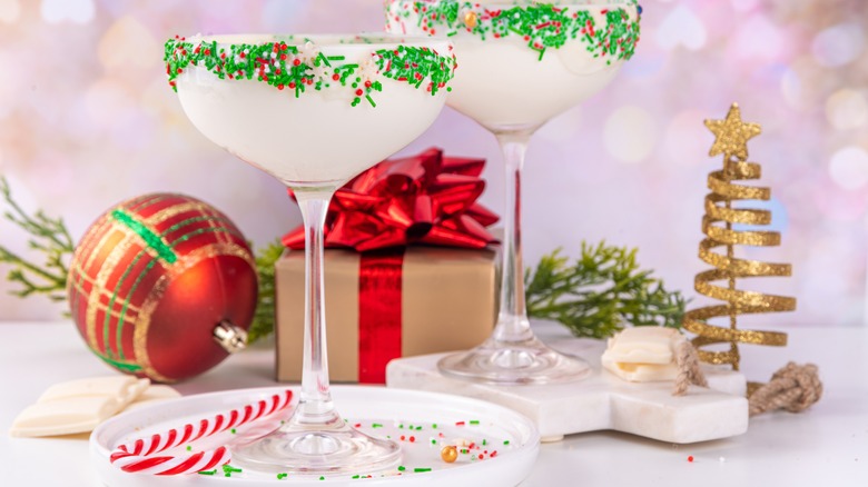 Two cocktail glasses have a frosting and sprinkle rim