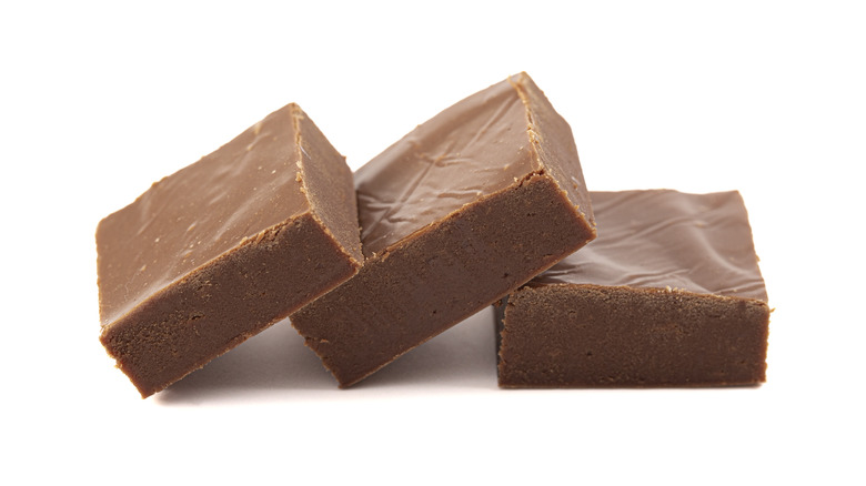 Three squares of fudge sit against a white background