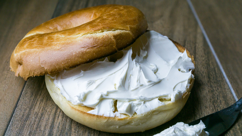 Frosting is spread on a bagel