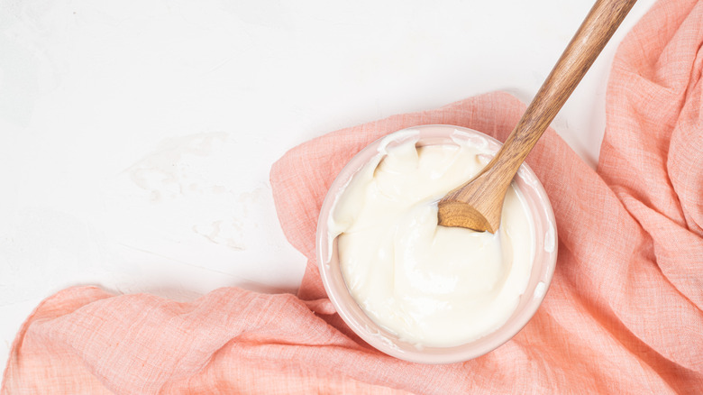 Frosting sits in a bowl with a wooden spoon