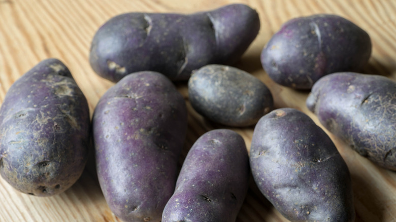 Purple potatoes on a wooden surface