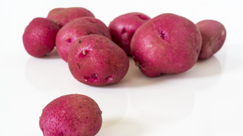 Red potatoes on a white surface and background