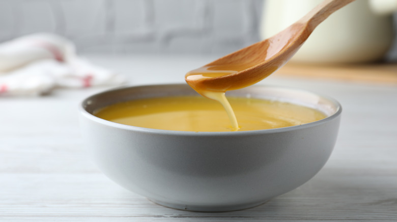 Spoon scooping clarified butter from bowl
