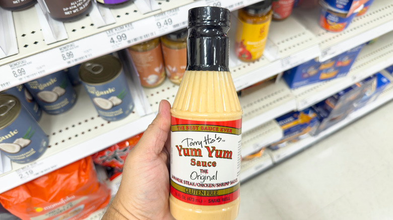 Hand holding bottle of yum yum sauce