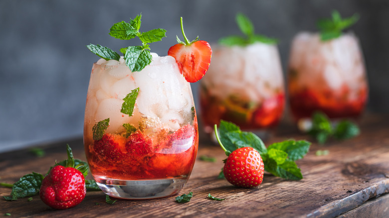 Three strawberry Mojitos with strawberry and mint garnishes