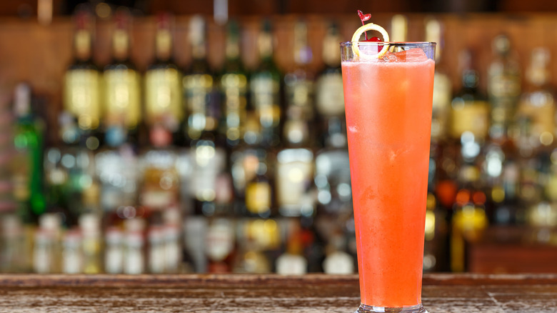 A strawberry-flavored Tom Collins cocktail on a bar counter