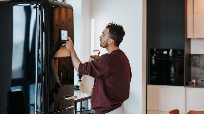 Person touching screen on a fridge