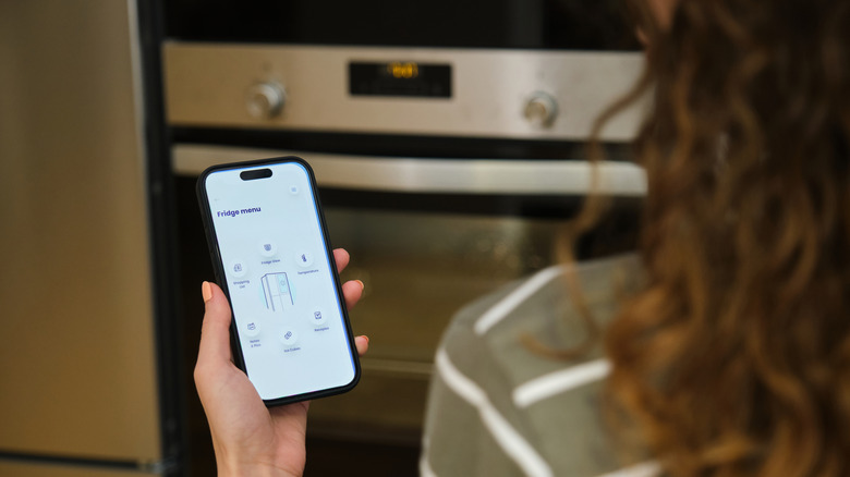 Person controlling a smart fridge from their phone
