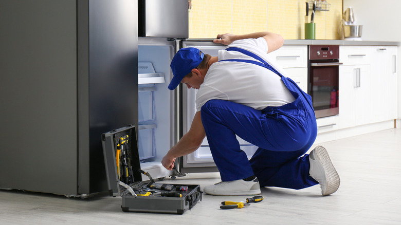 Person working on a fridge in a kitchen