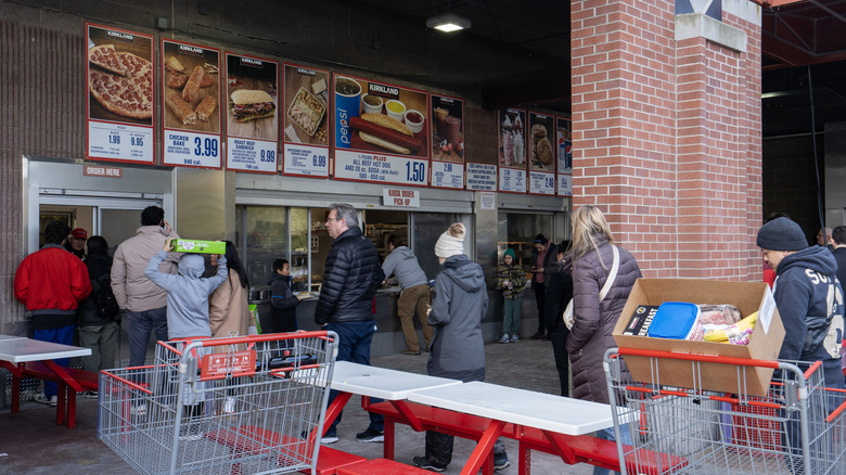 an outdoor Costco food court with customers lined up to order