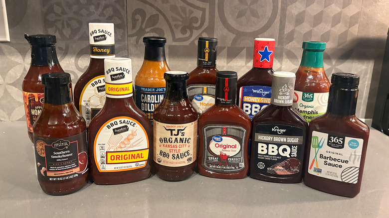 12 bottles of BBQ sauces lined up on a counter