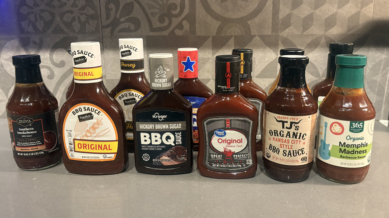 12 bottles of BBQ sauces lined up on a counter