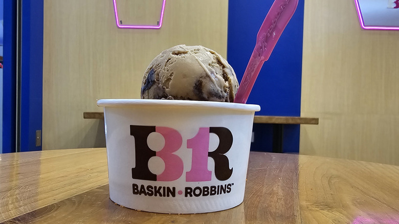 A Baskin-Robbins cookie 'n creme scoop in a cup.