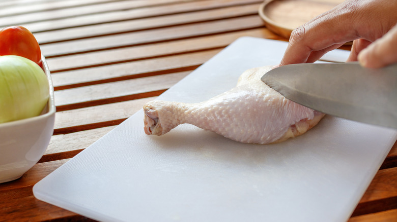 Person cutting a drumstick with a knife