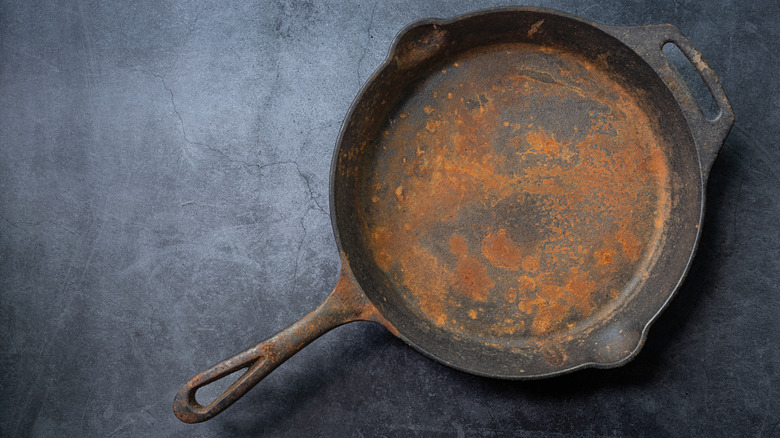 Rusted cast iron pan on gray background