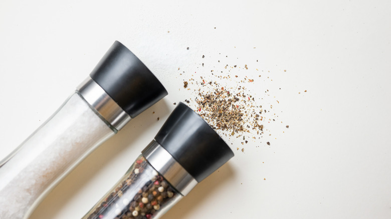 Salt and pepper grinders on white background