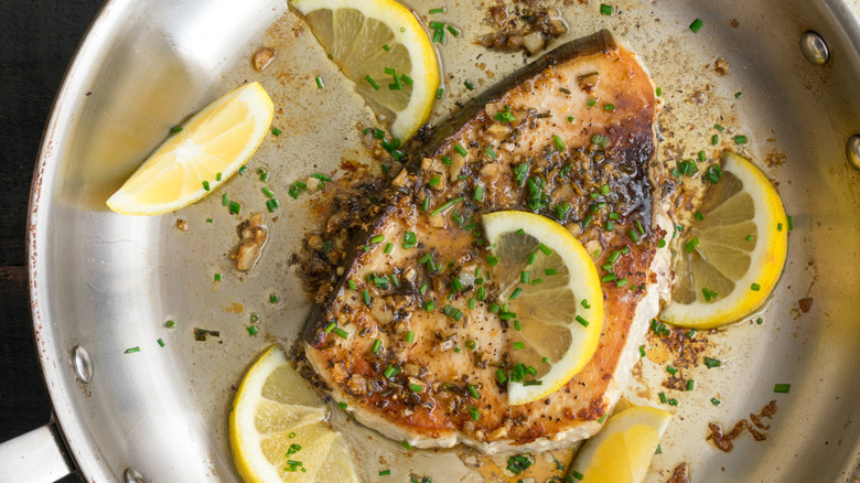 Piece of fish in a stainless steel pan