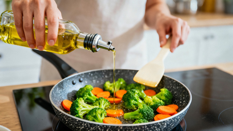 Person cooking vegetables and holding spatula