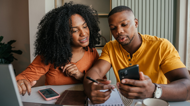 A couple is going over something on their computers together
