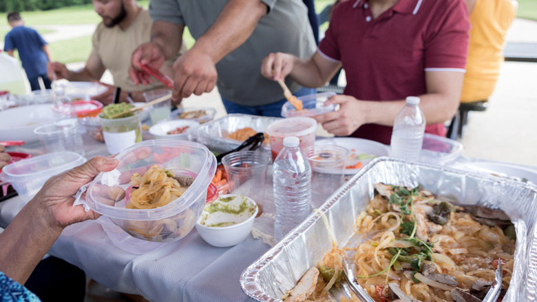People packing up picnic leftovers