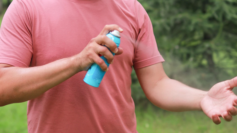 Man putting on bug spray