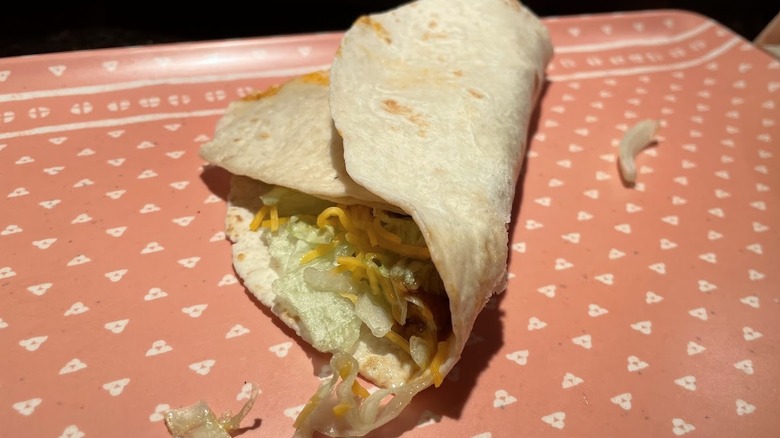 A slice of quesadilla stuffed into a soft taco