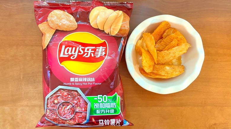 dark red Numb & Spicy Hot Pot chip bag next to a white bowl of chips