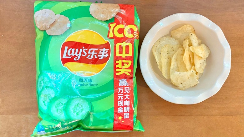 green Cucumber chip bag next to a white bowl of chips