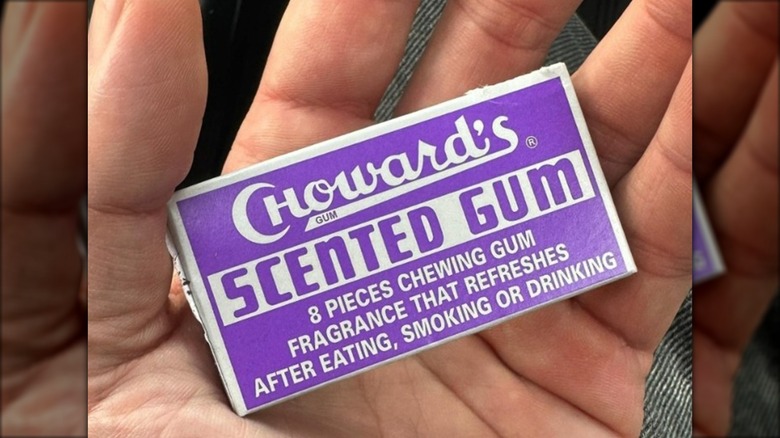 A person holding a pack of Violet Mint Choward's Scented Gum