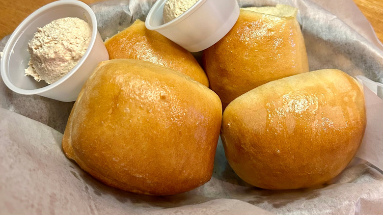 A basket of Texas Roadhouse rolls with butter