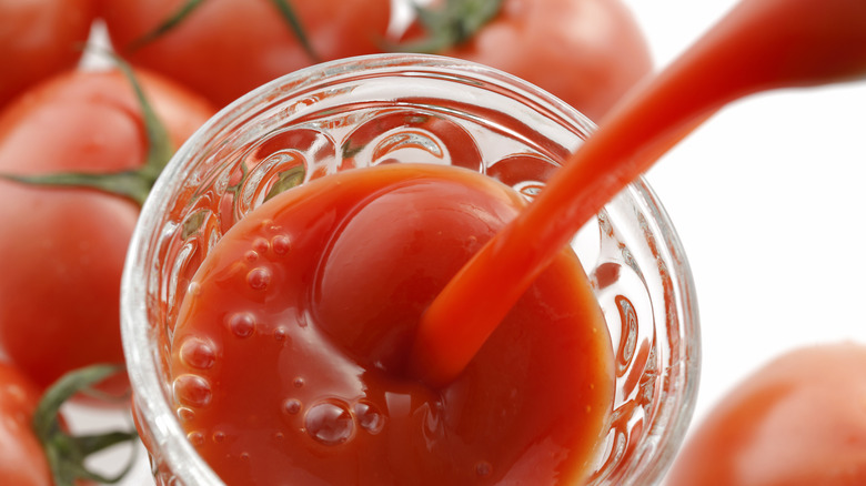 Pouring tomato juice into cup