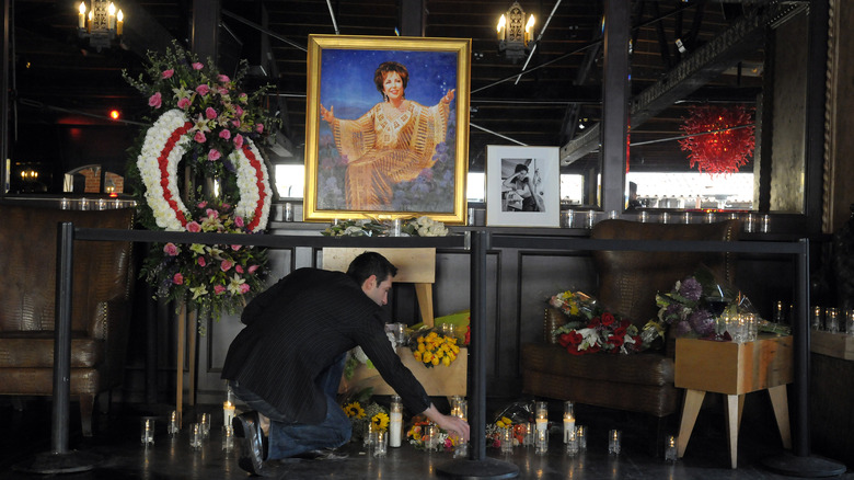 A man rearranging candles at Elizabeth Taylor's memorial shrine at The Abbey