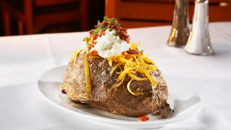 A loaded baked potato on a plate at Ocean Prime