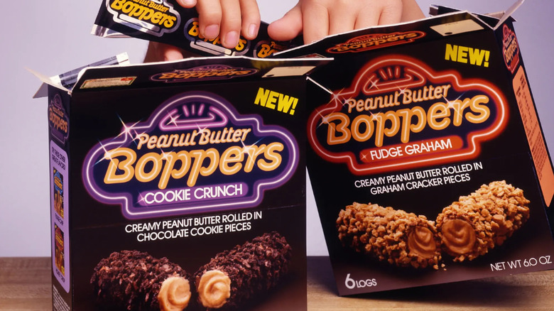 Hands reaching into two boxes of Peanut Butter Boppers