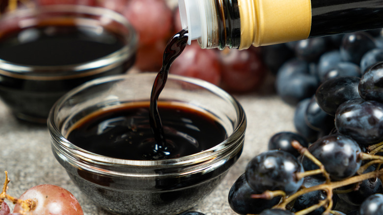 A pour of balsamic glaze into a glass bowl.