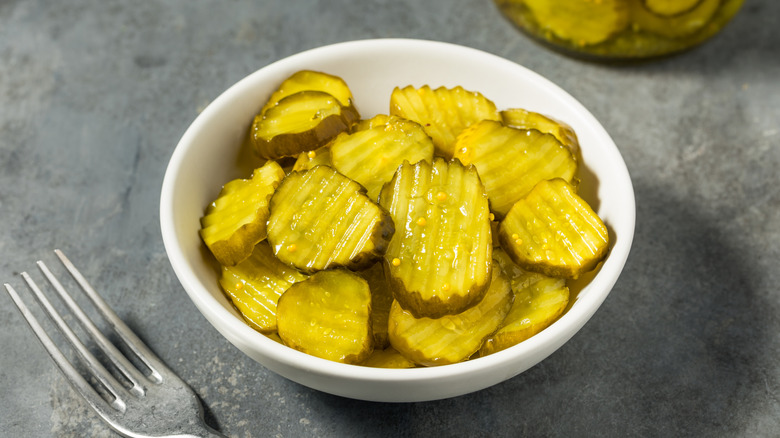 A bowl of bread and butter pickles.