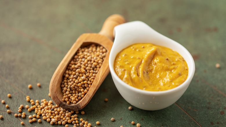 A bowl of honey mustard with a side of mustard seeds.