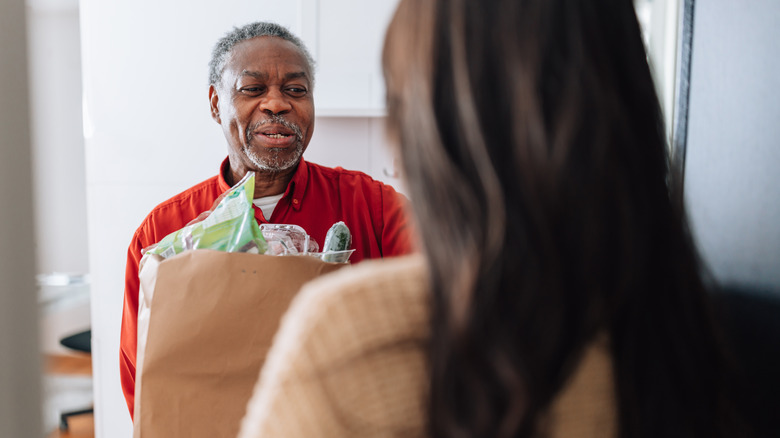 Man delivering groceries to a woman's door