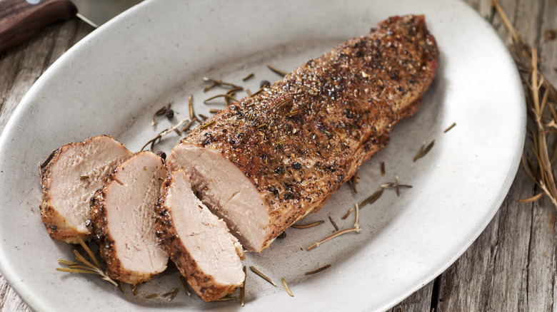 Pork tenderloin on a plate with herbs