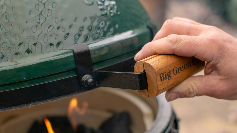 Person "burping" the Big Green Egg by opening it slightly