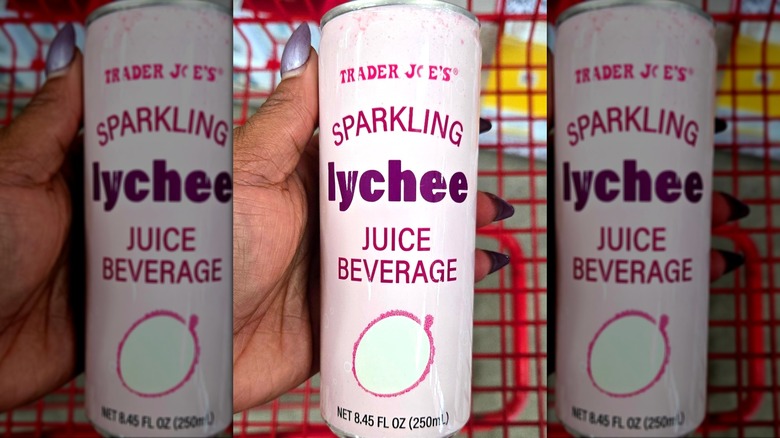 Hand holding can of sparkling lychee juice beverage