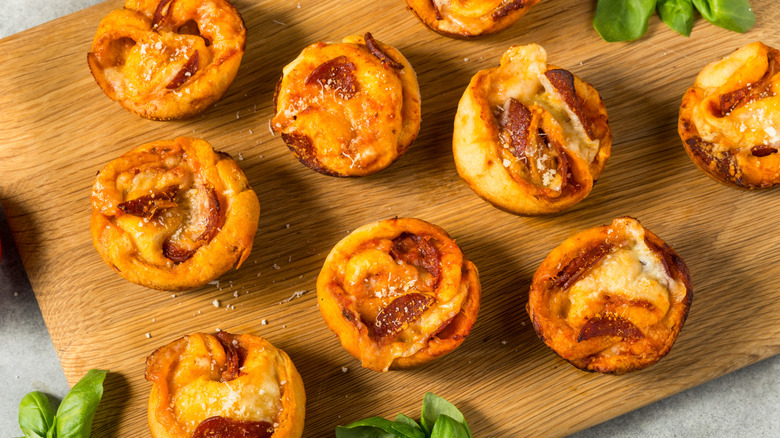 Muffin pizza cups on brown wooden board
