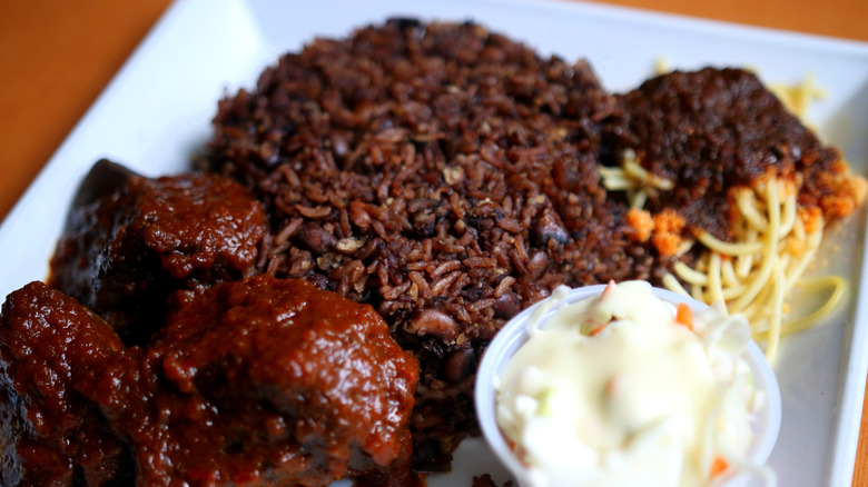 Waakye with sides of spaghetti, stewed meat, and sauce