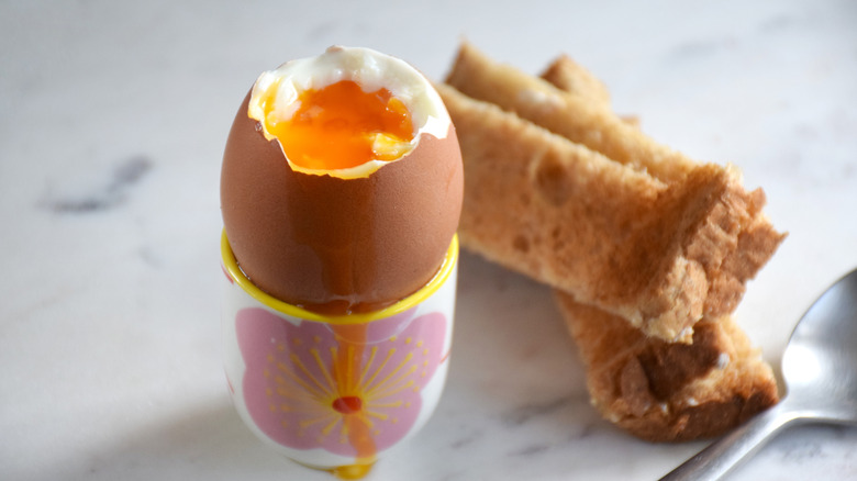 Soft boiled egg and soldiers on a marble table