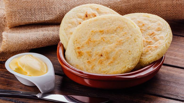 Arepas andinas in a ceramic dish with butter