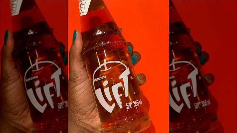 person holding bottle of Lift Manzana